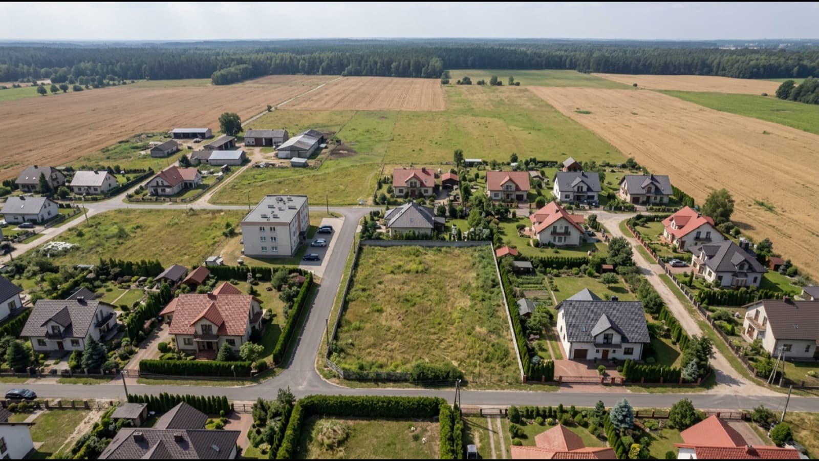 Pusta działka budowlana wśród domów jednorodzinnych, z jednym budynkiem wielorodzinnym w sąsiedztwie